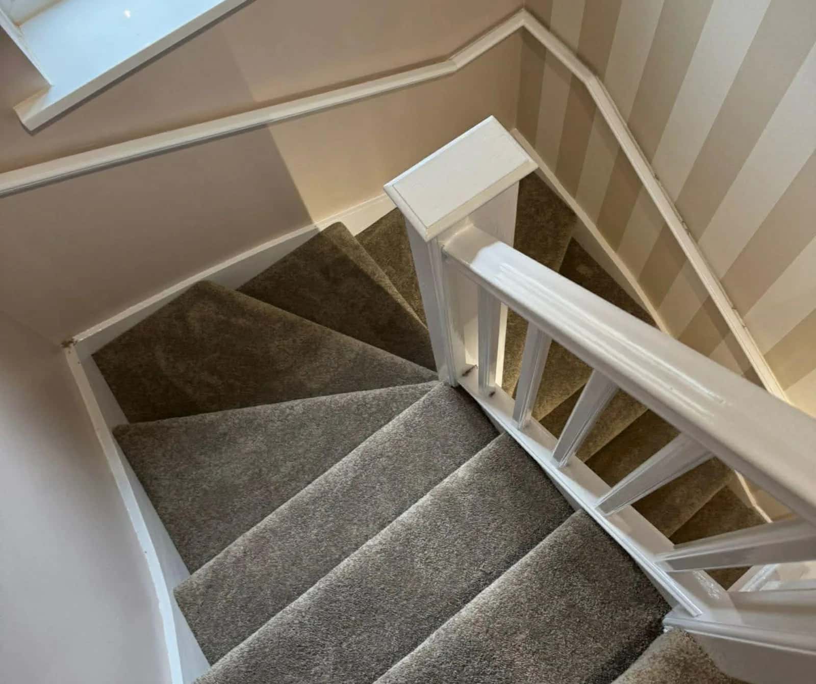 Grey carpet fitted to a winding staircase