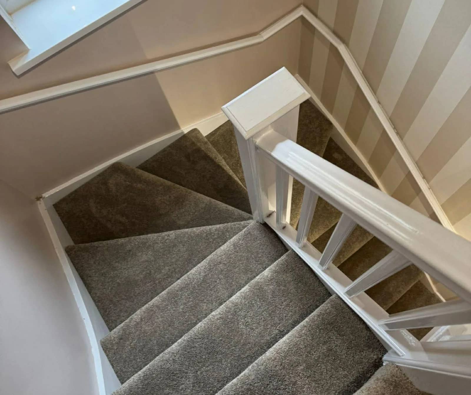 Grey carpet fitted to a winding staircase