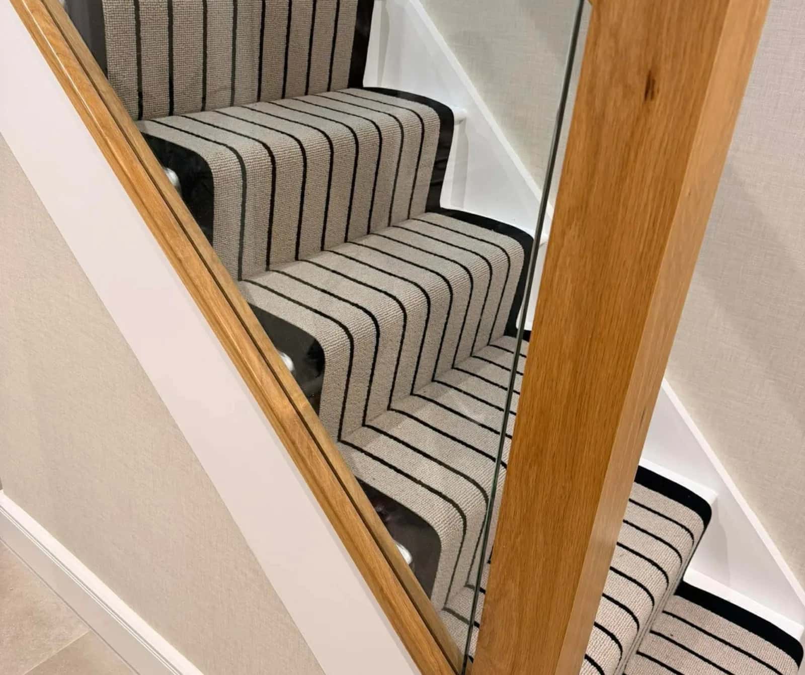 Striped stair runner against an oak handrail