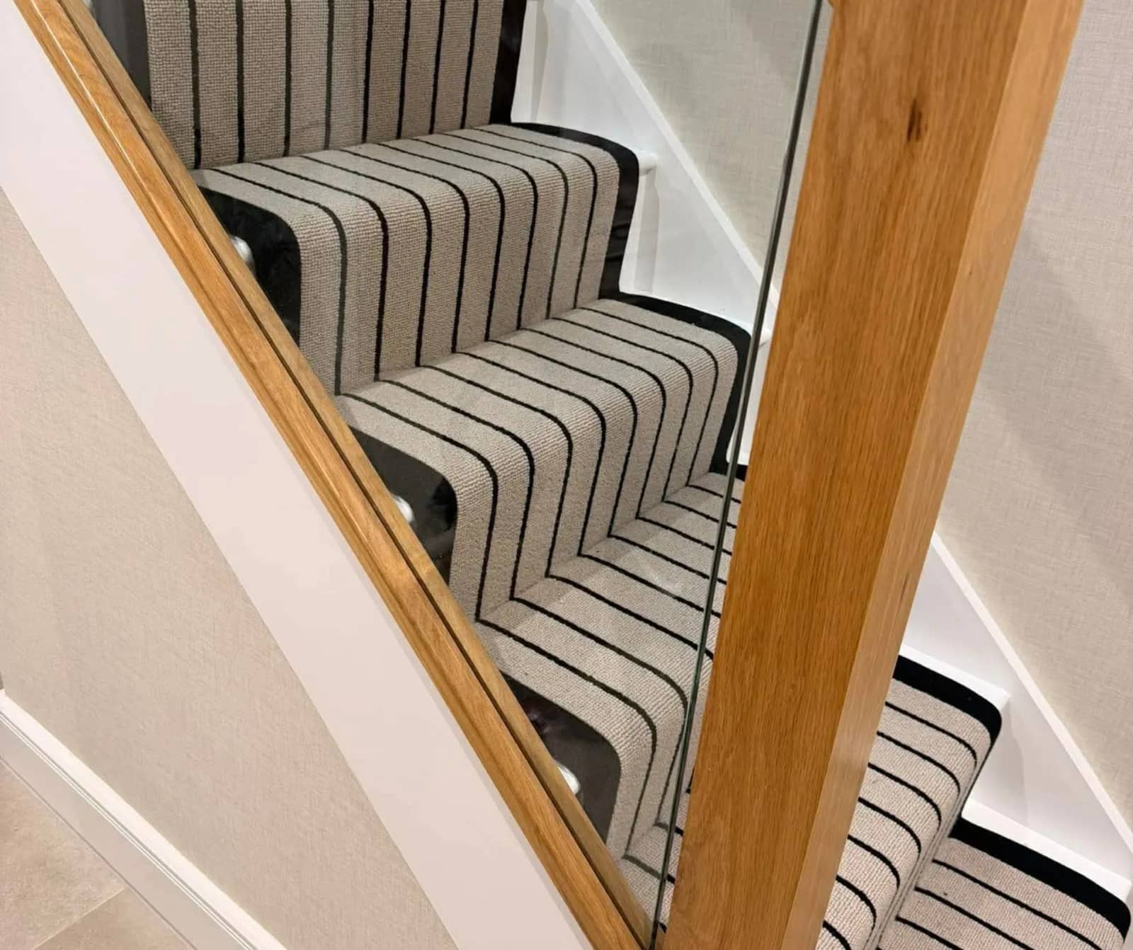 Striped stair runner against an oak handrail