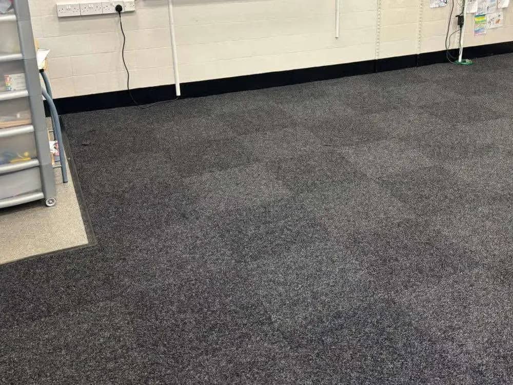 Heavy duty carpet tiles laid in a checkerboard pattern across a classroom floor