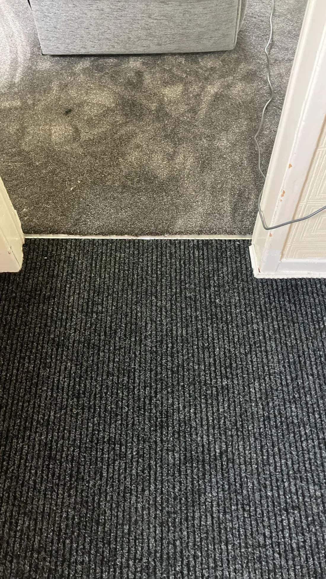 Carpet tiles meeting a corded entrance mat