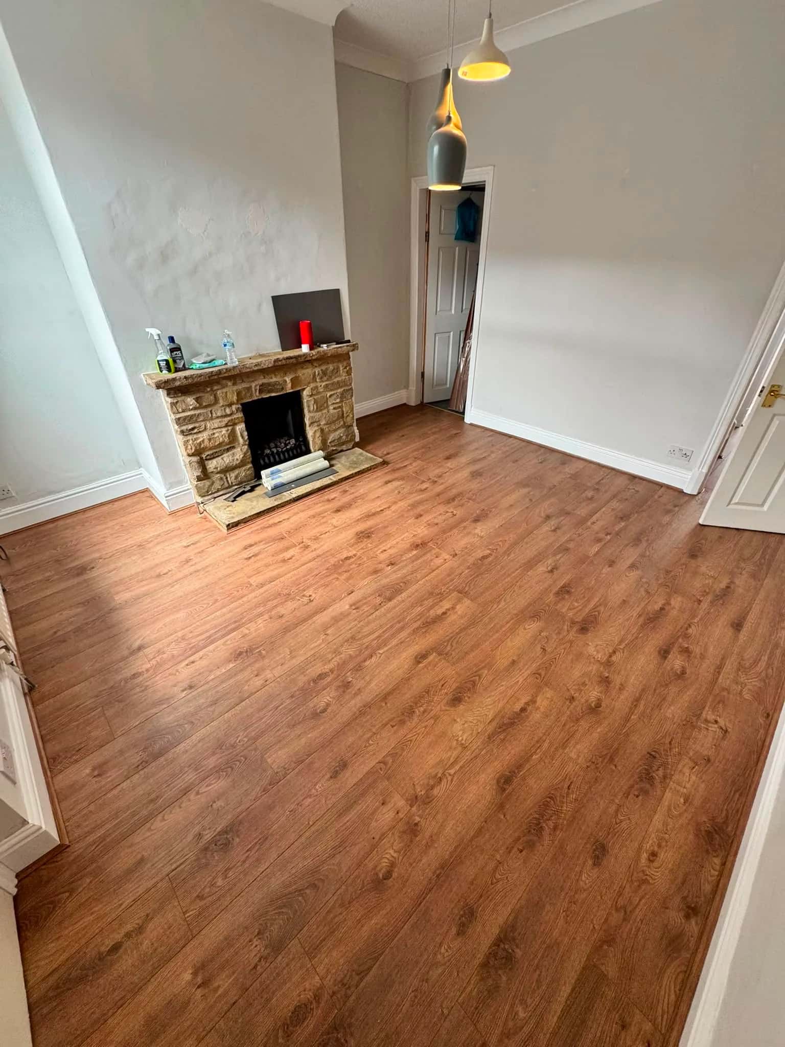 Oak effect laminate fitted across a living room with a stone fireplace