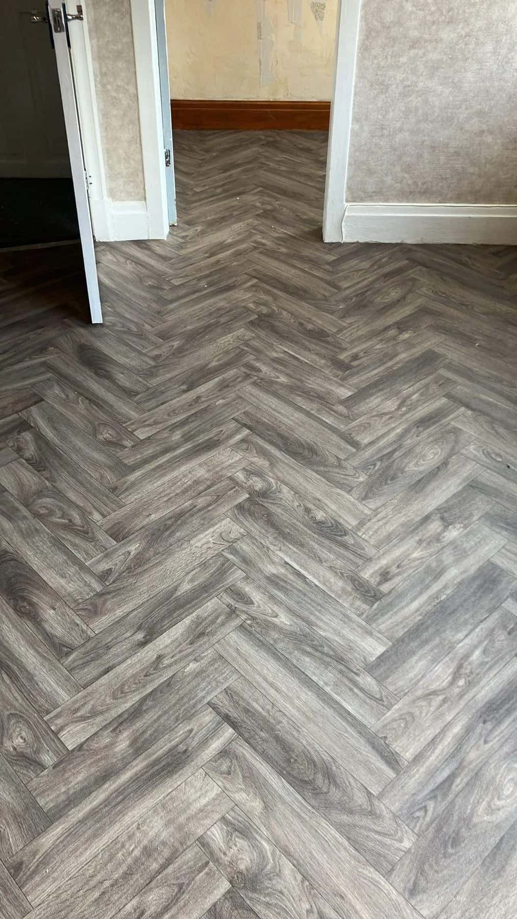 Grey herringbone luxury vinyl tile laid across a hallway