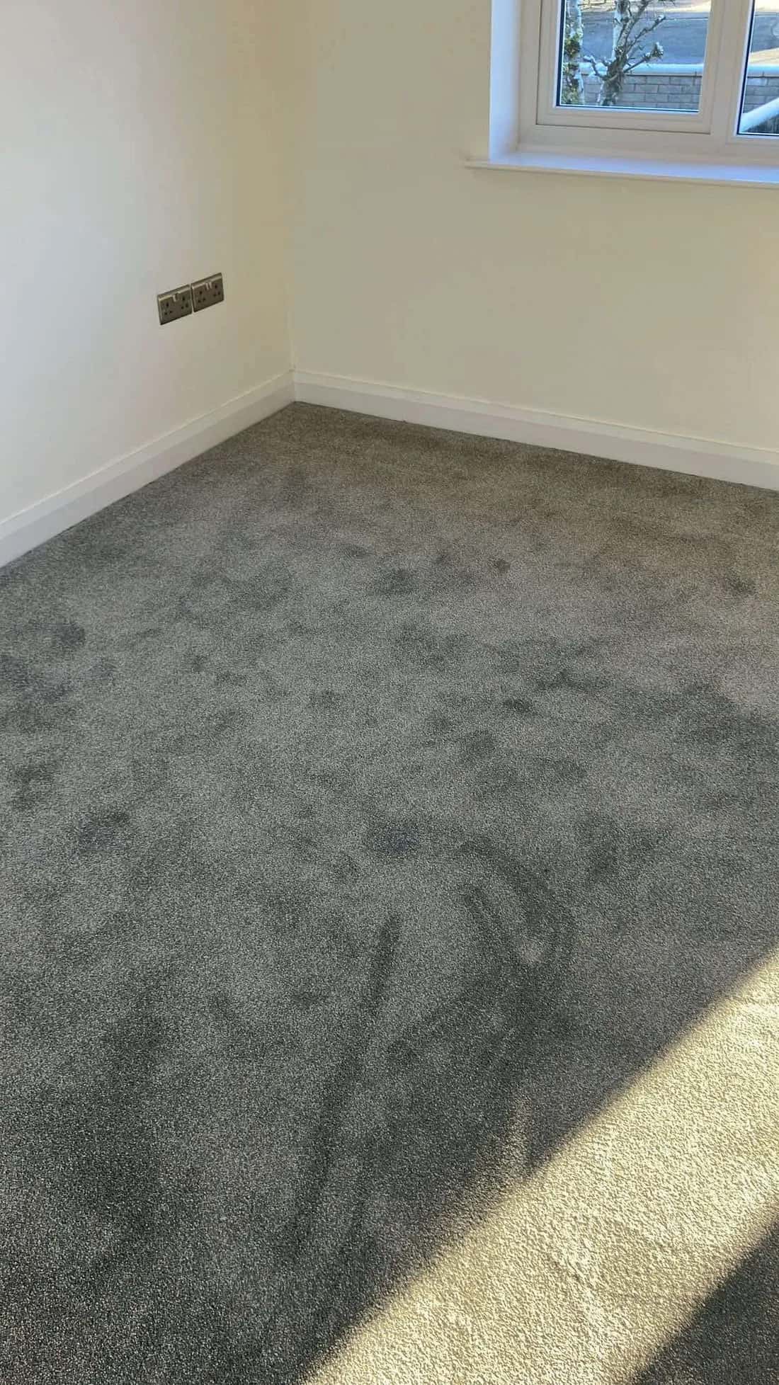 Grey carpet fitted in a bedroom under the window
