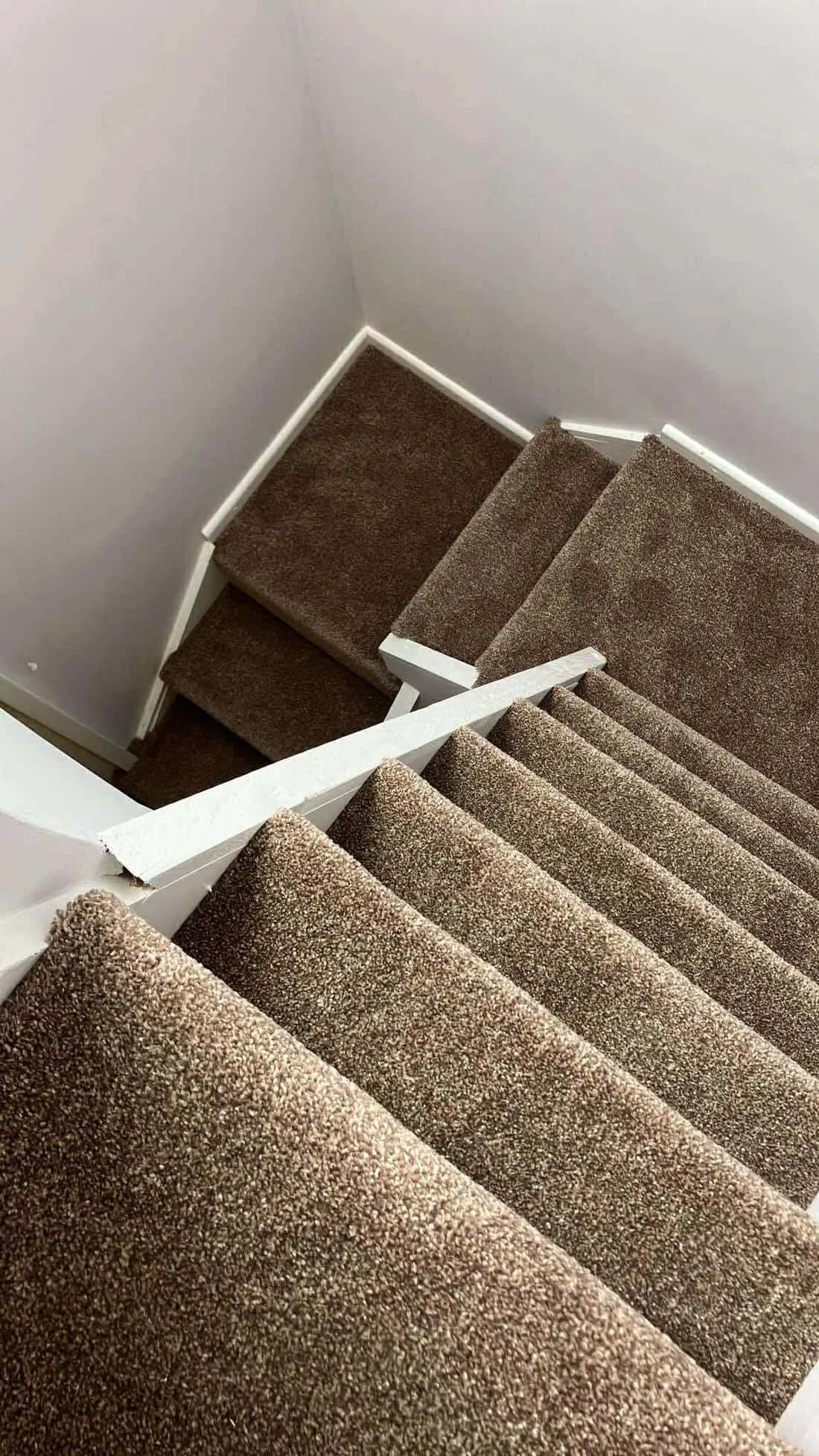 Brown carpet fitted to a turning staircase