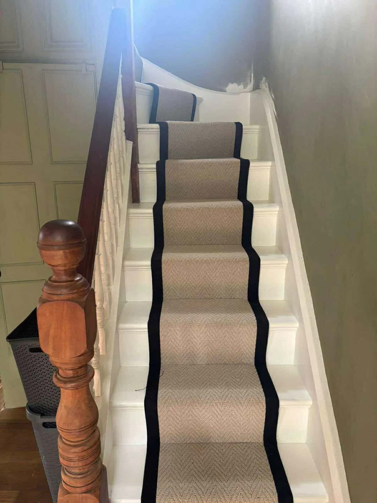A bordered runner on a staircase with a turned wooden banister