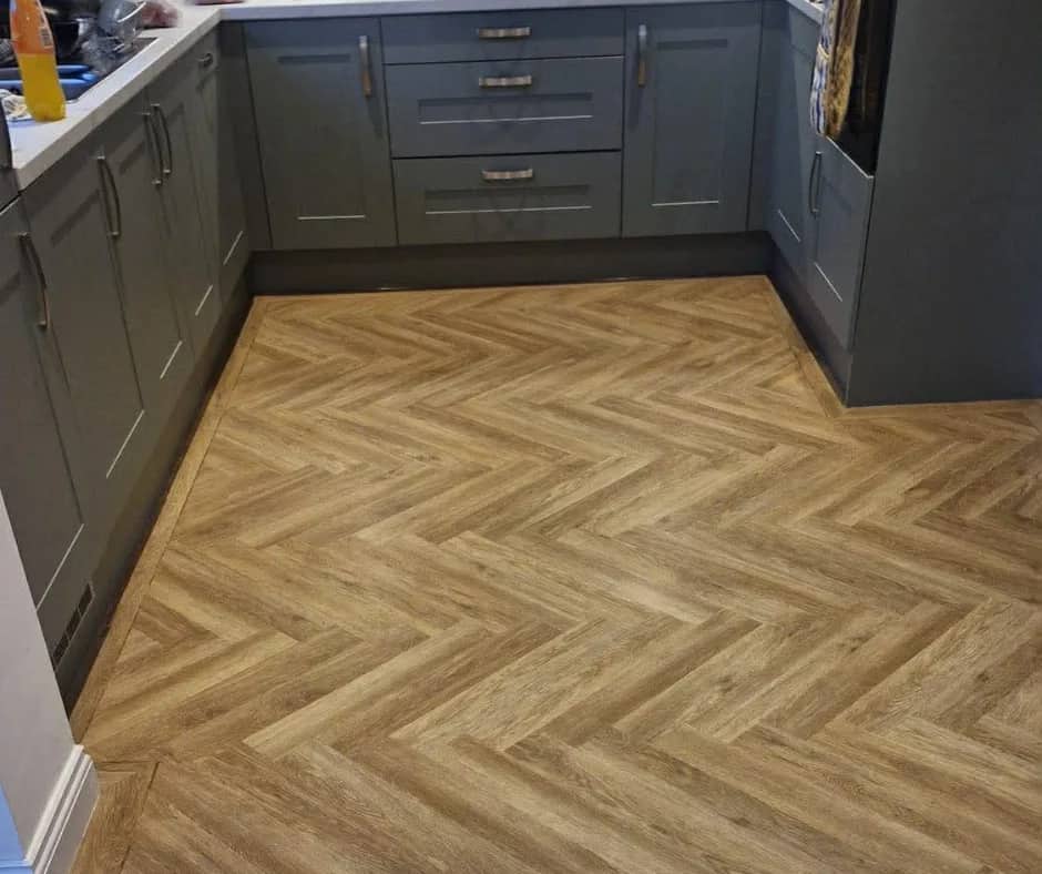 Herringbone flooring in a kitchen with grey units