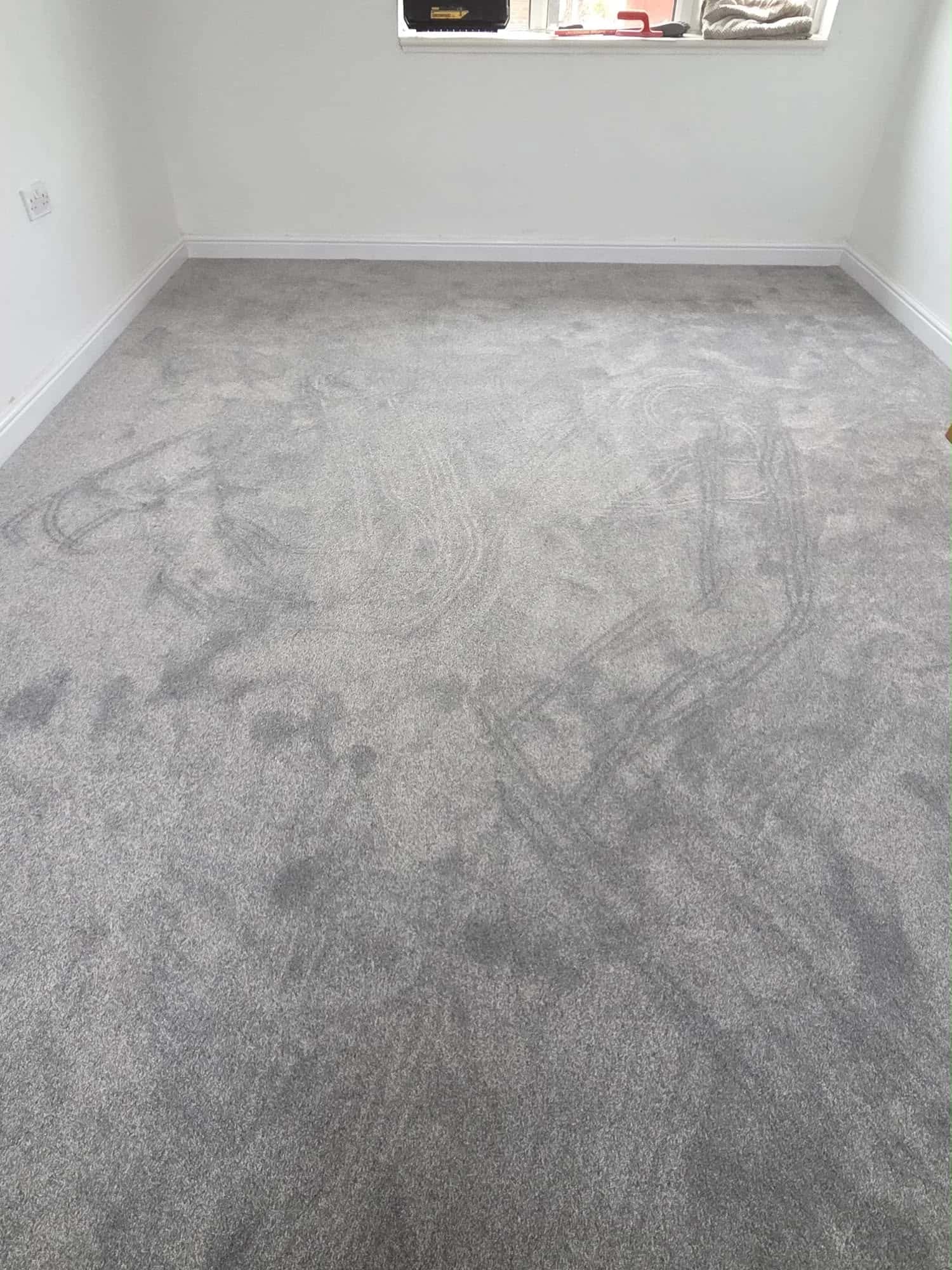 Grey carpet fitted wall to wall in an empty room
