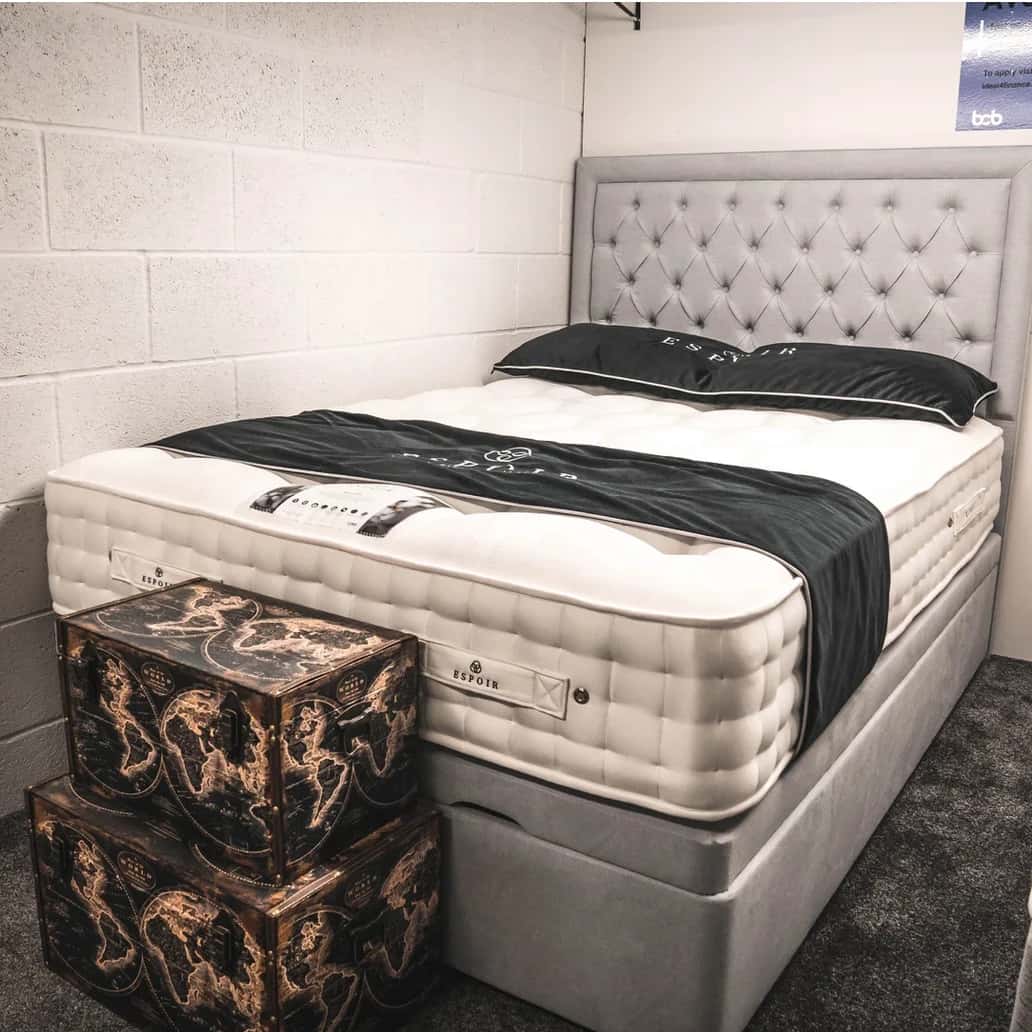 A divan bed made up with a tall buttoned headboard on the Boundary Carpets and Beds showroom floor in Colne