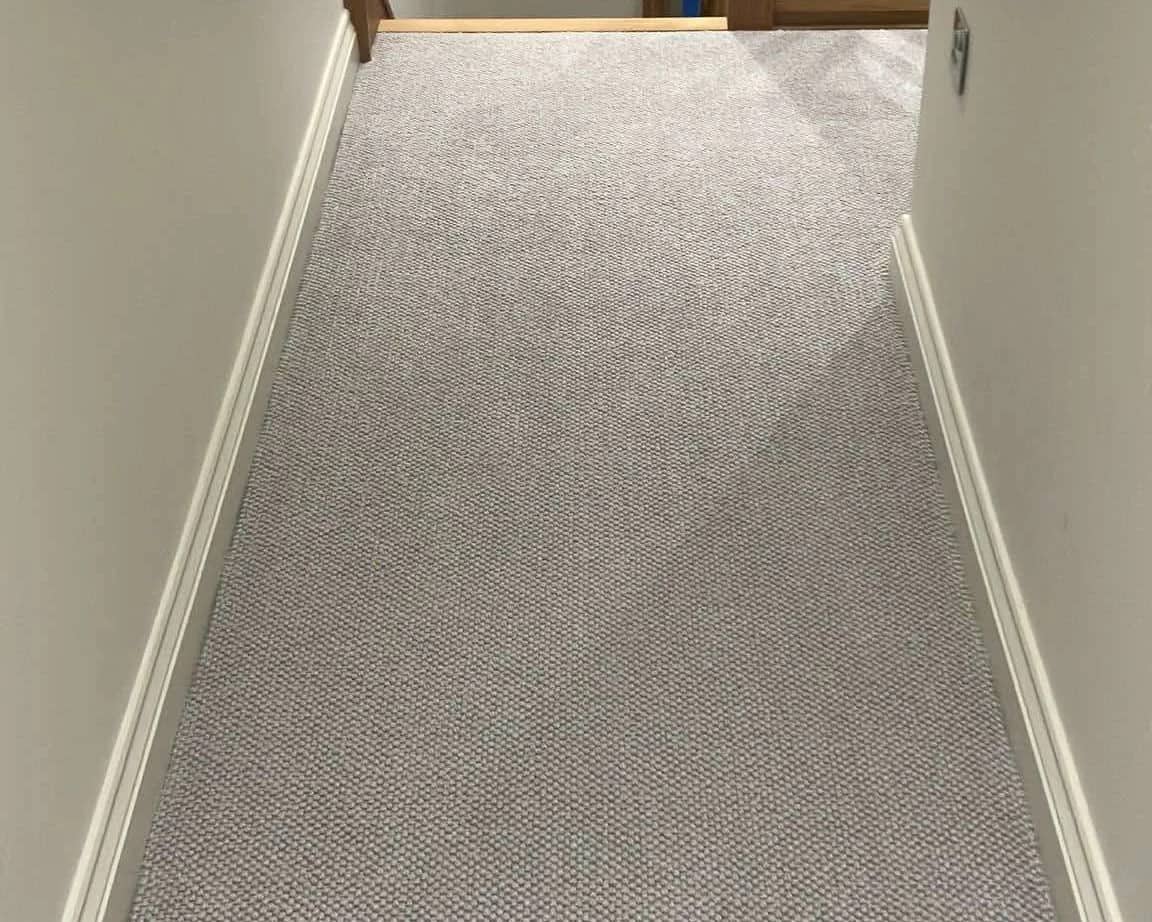 Grey carpet fitted the length of a narrow landing, cut in tight to both skirtings