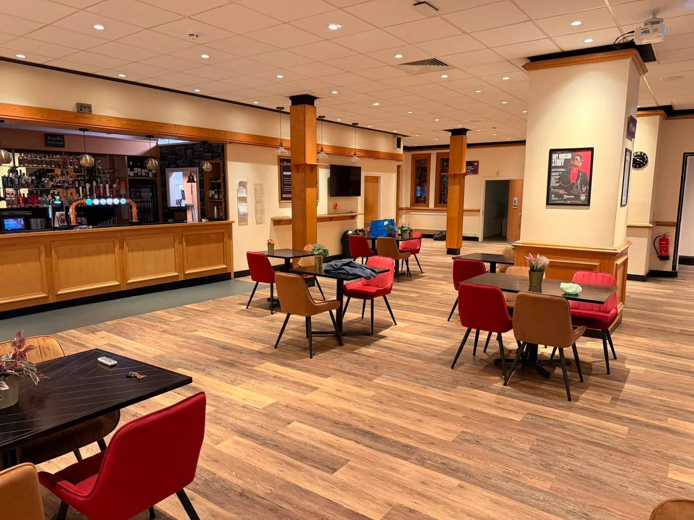 The finished bar area at Burnley Mechanics on wood effect vinyl plank, with tables and chairs back in place