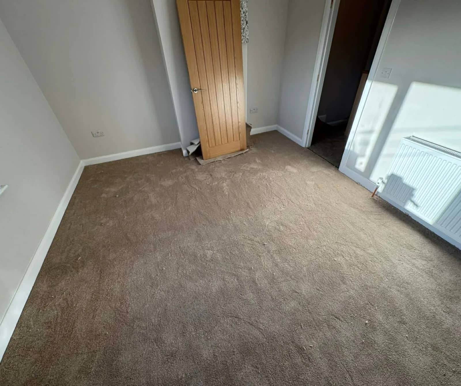 Plain carpet fitted across an empty room
