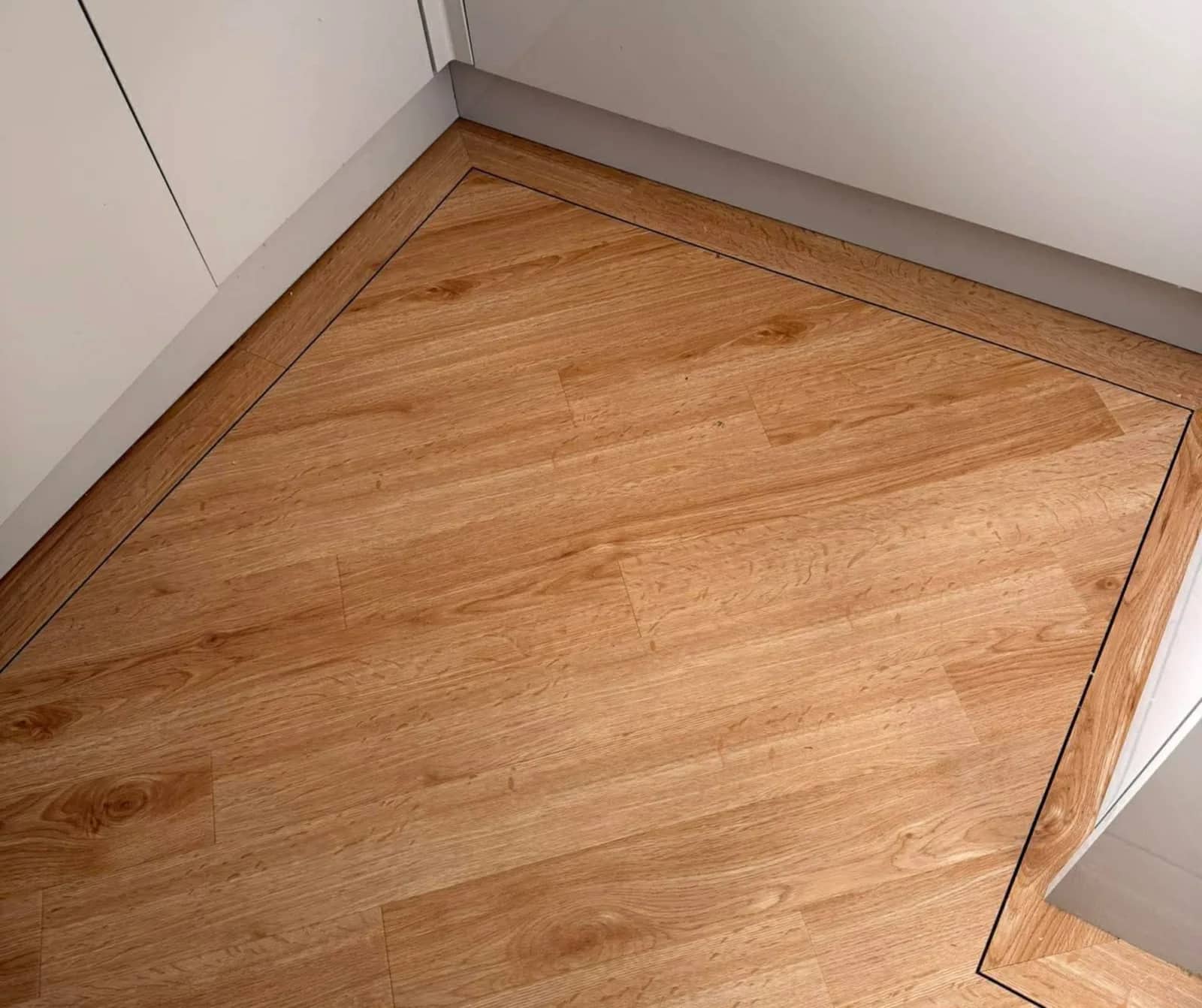 Oak effect flooring against white skirting