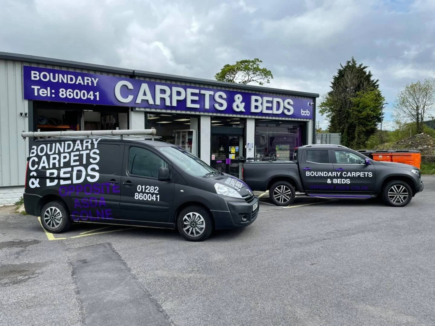 The Boundary Carpets and Beds shopfront in Colne, with the company vans parked outside