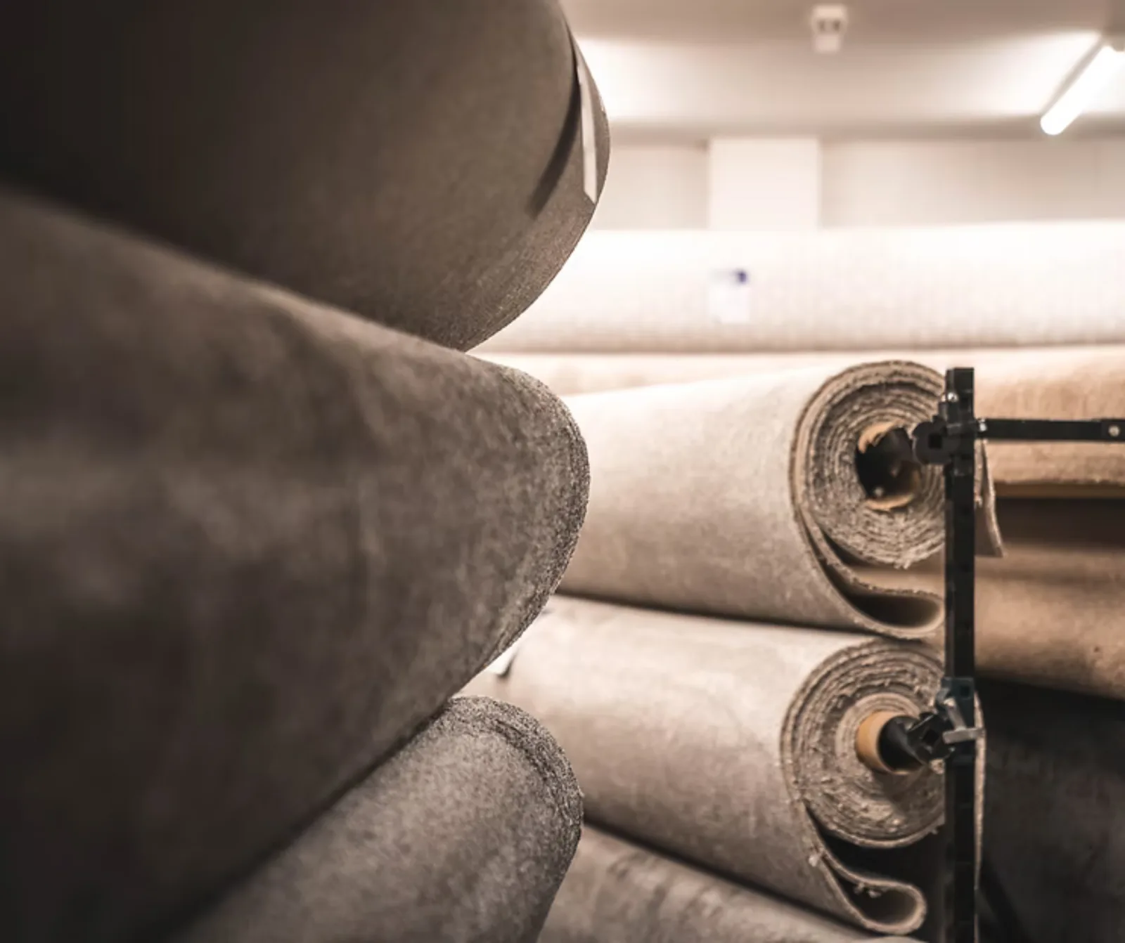 Rolled carpets stacked on the showroom floor, showing pile and backing