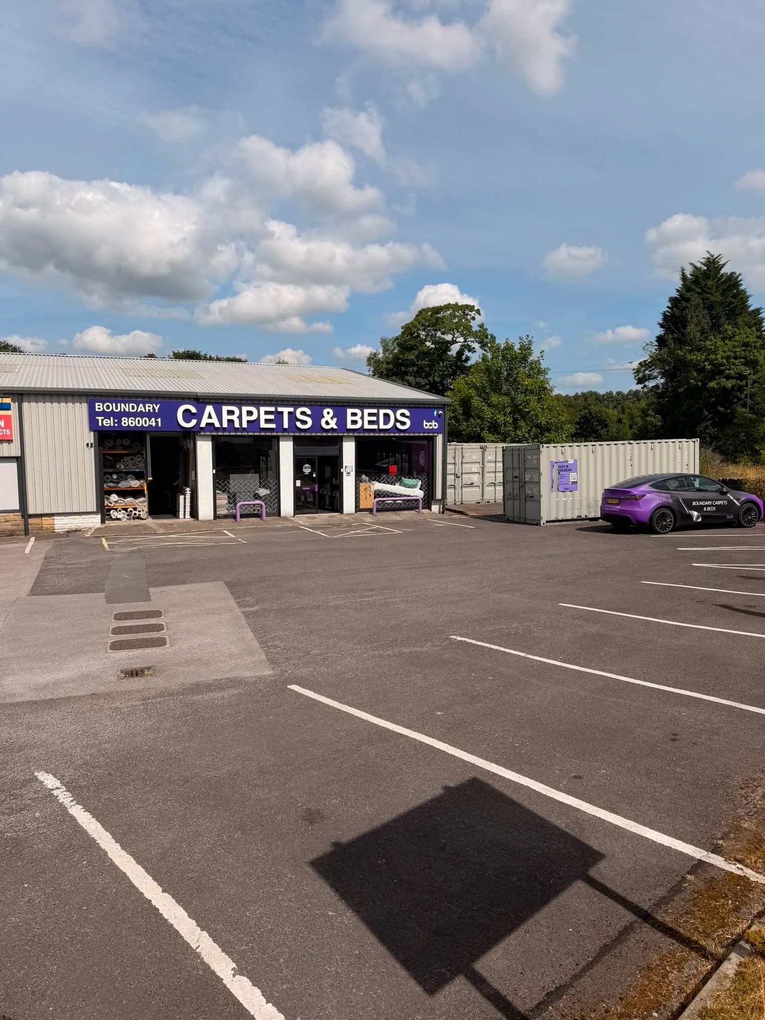 The purple and white Boundary Carpets & Beds shopfront on Unit 3 Regent Street, with parking directly outside
