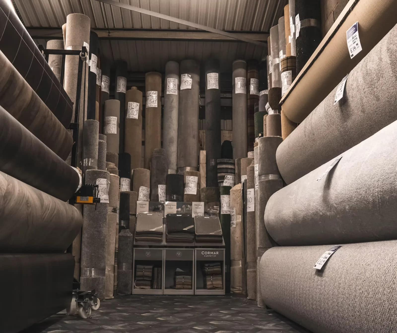 Rolls of carpet stood on end in the stockroom, ready to be cut